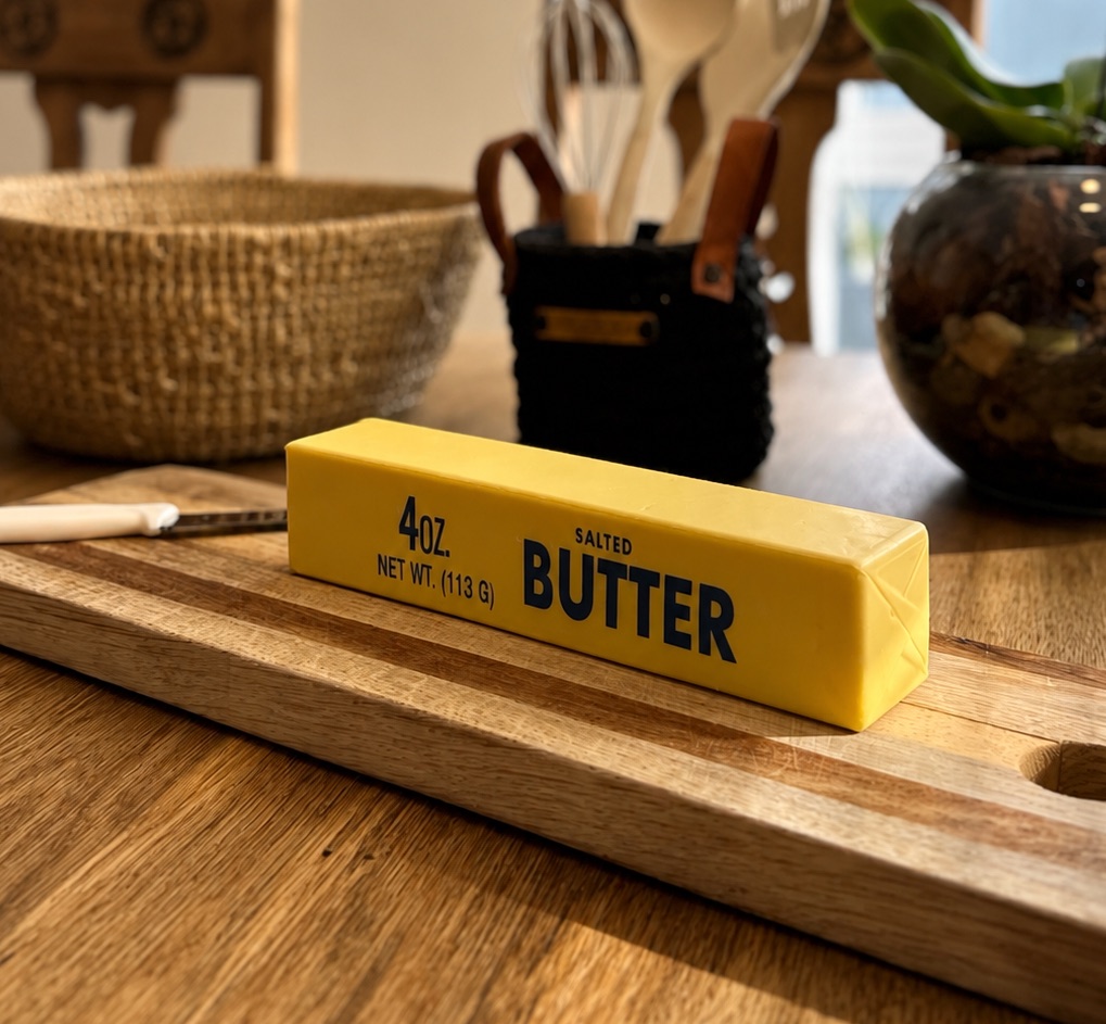 Jumbo yellow butter bar squishy displayed on a wooden chopping board
